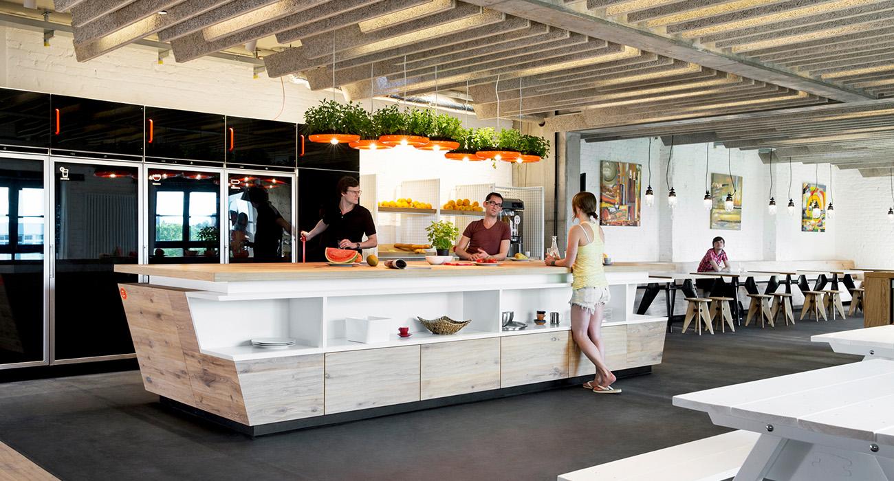 Delafair Innenausbau Berlin: Büroausbau - Kücheninsel mit Theke für Mitarbeiter in hellen freundlichen Farbtönen mit Holz